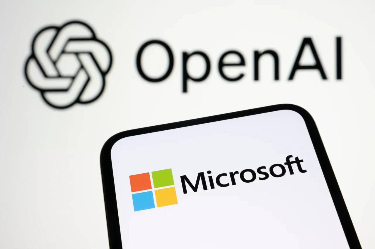 The Microsoft logo appears on a smartphone screen with the OpenAI logo in the background. (Photo by Samuel Boivin/NurPhoto via Getty Images)