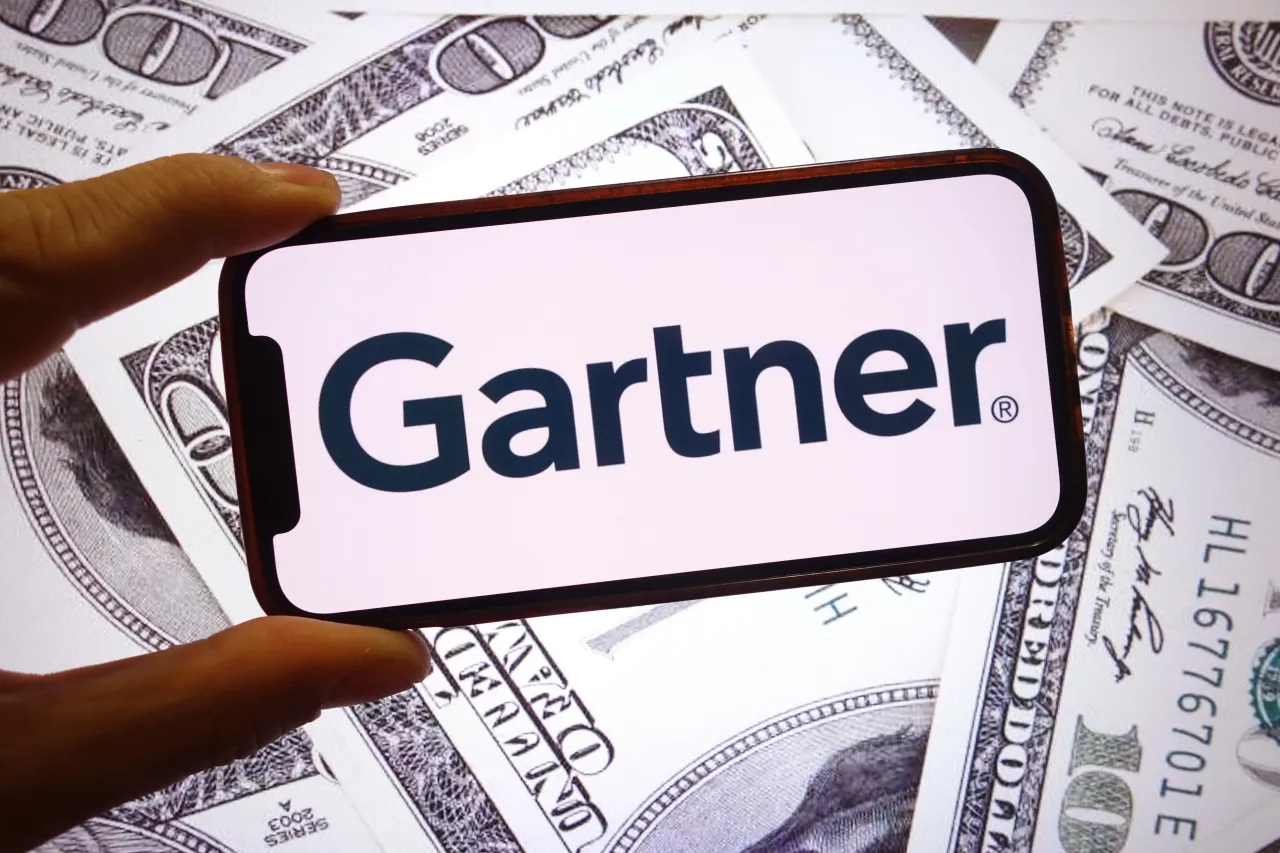 In this photo illustration, the Gartner company logo is seen displayed on a smartphone screen with United States dollar banknotes in the background. (Photo Illustration by Piotr Swat/SOPA Images/LightRocket via Getty Images)