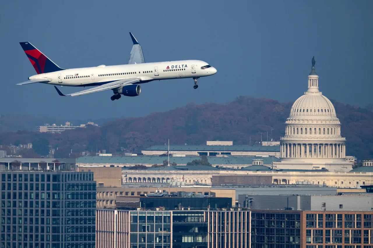 A Delta Airlines Boeing 757-200 plane passes by the U.S. Capitol dome in Washington as it comes in for a landing at Ronald Reagan Washington National Airport on Sunday, November 9, 2025.