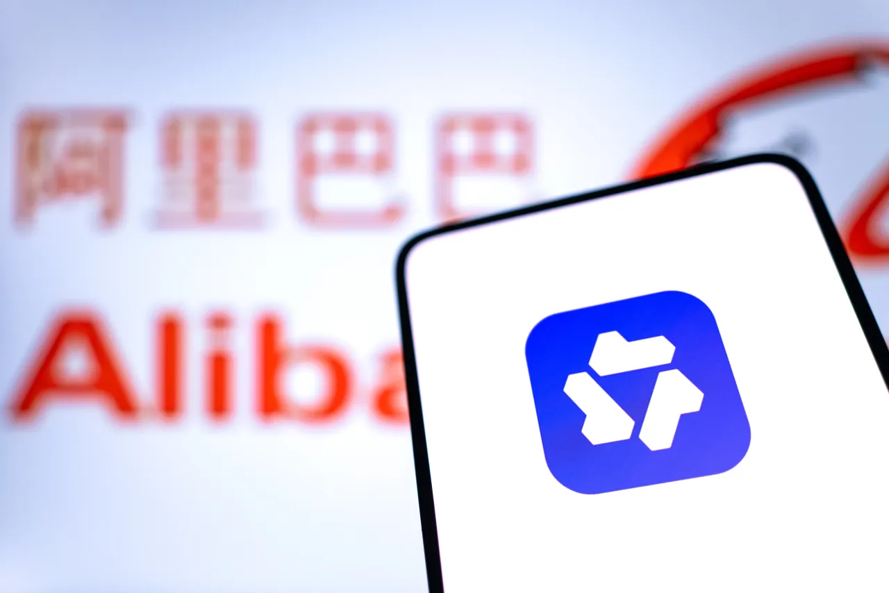 The logo of chatbot app Qwen is displayed on a smartphone screen, with Alibaba branding in the background. (Photo by Qin Zihang/VCG via Getty Images)