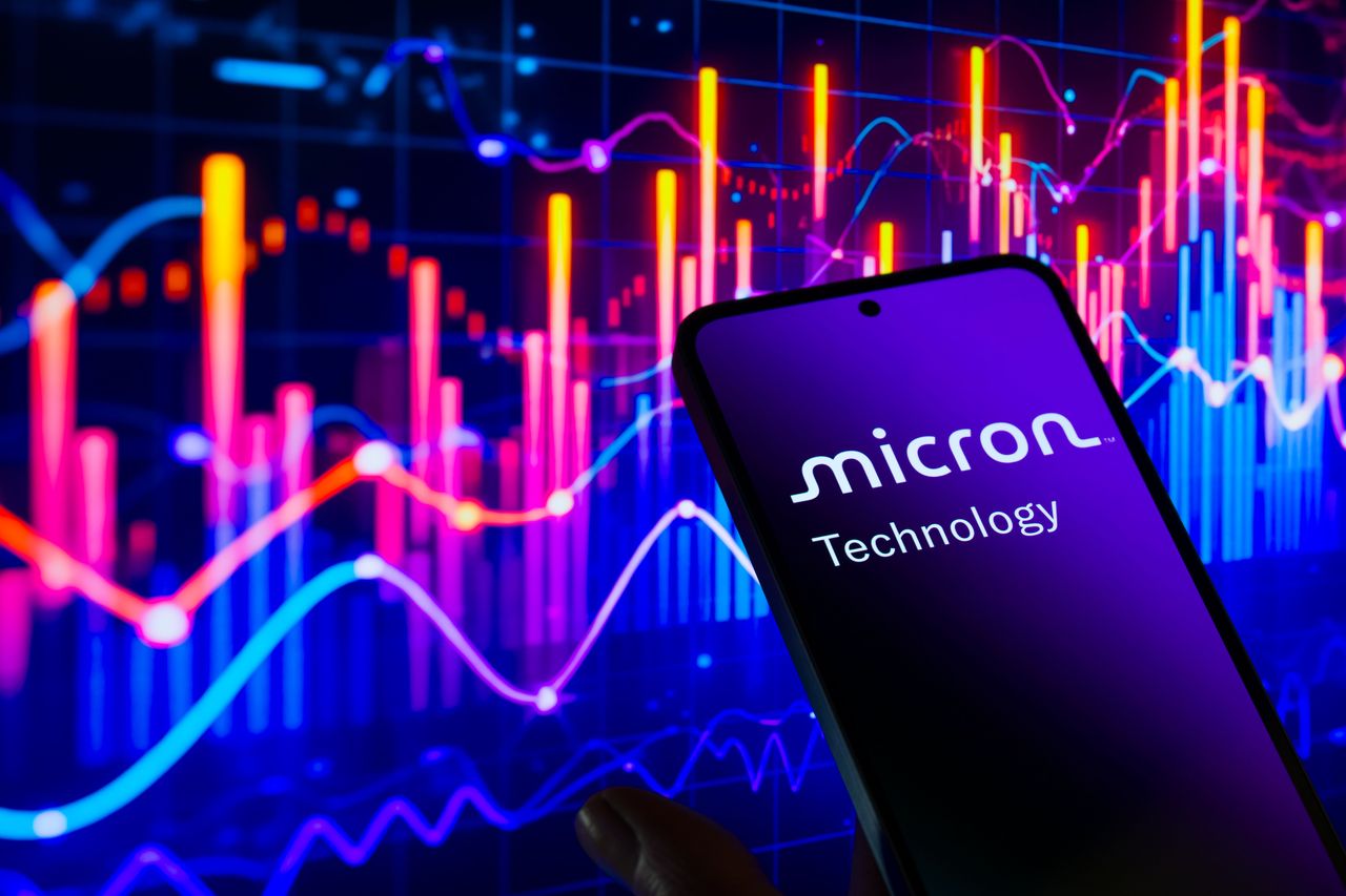 The Micron Technology Ink logo is displayed on a mobile phone with a financial stock graph visible in the background. (Photo by Jonathan Raa/NurPhoto via Getty Images)