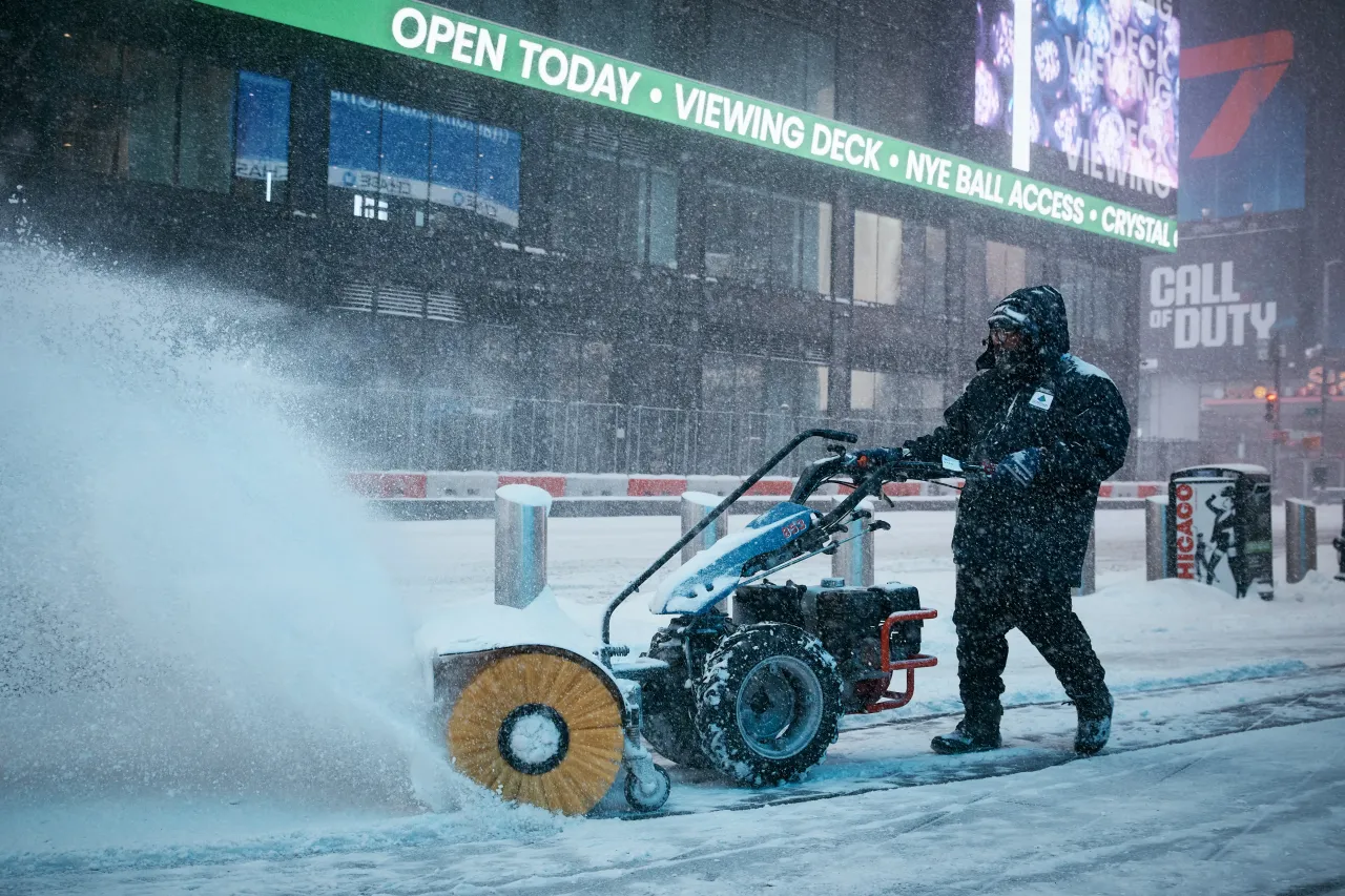 A worker clears the walking side in Times Square during a snowstorm on January 25, 2026 in New York City. A massive winter storm is bringing frigid temperatures, ice, and snow to nearly 200 million Americans.