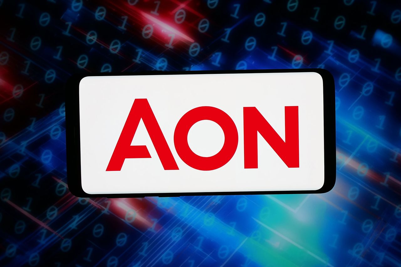 In this photo illustration, the logo of British professional services company Aon plc is seen displayed on a smartphone in front of an abstract background on a computer screen. (Photo Illustration by Timon Schneider/SOPA Images/LightRocket via Getty Images)