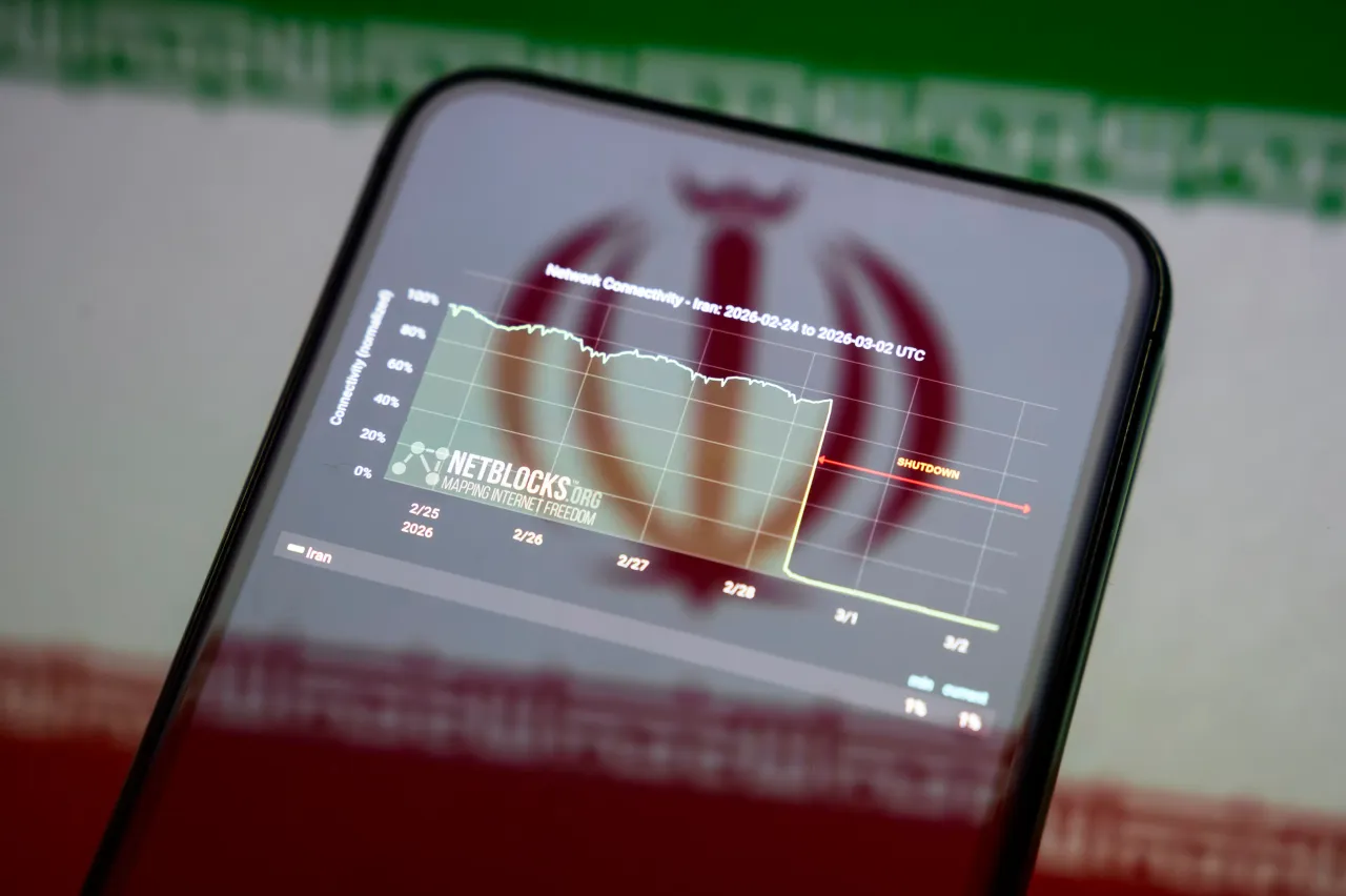 NetBlocks' graphic on the internet connectivity shutdown in Iran is displayed on a smartphone screen placed on a reflective surface onto which the Iranian flag.(Photo by Samuel Boivin/NurPhoto via Getty Images)