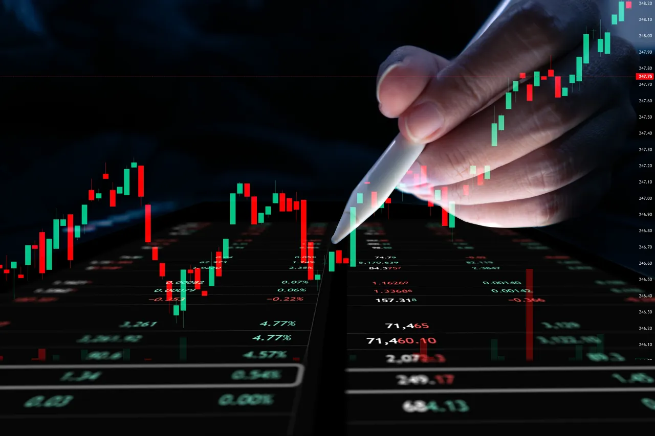 Hands using a mobile phone to analyze financial data with a laptop in the background, displaying graphs and charts for business planning. - stock photo