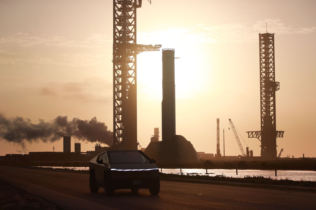 A Tesla Cybertruck drives in front of SpaceX's South Texas Launch Site in Cameron County, Texas, on April 13, 2026. Booster 19, or ''B19,'' is visible in the background. (Photo by Reginald Mathalone/NurPhoto via Getty Images)