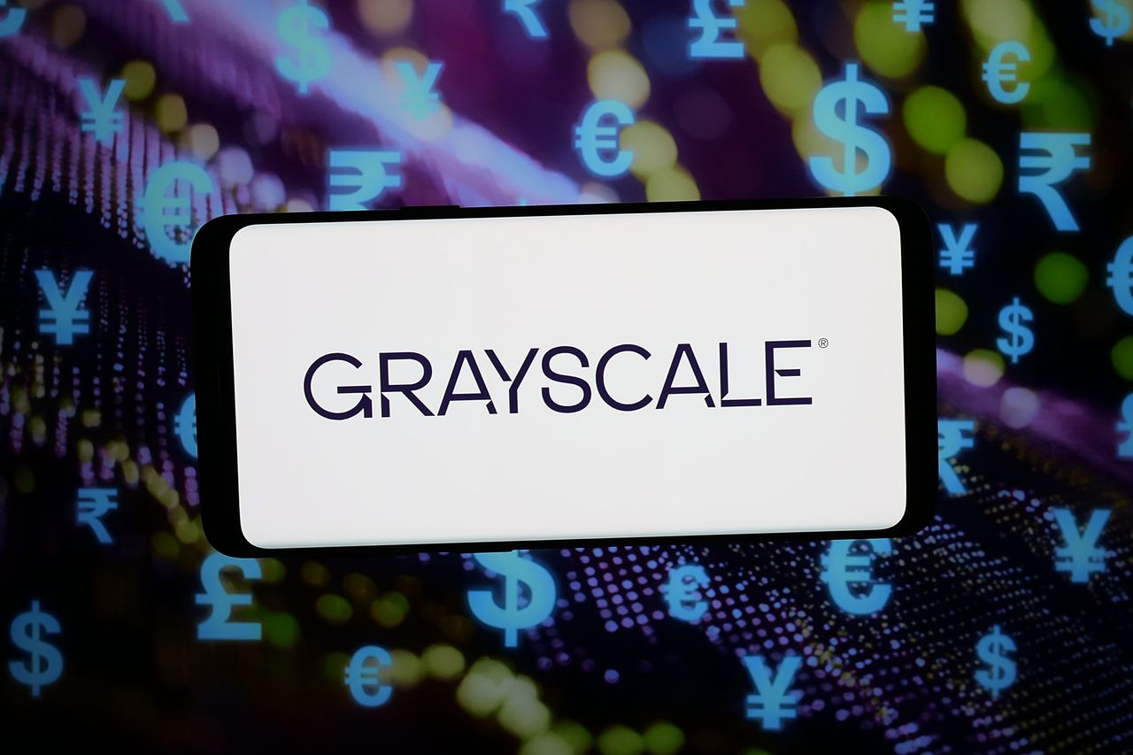  In this photo illustration, the logo of crypto investment company Grayscale is displayed on a smartphone in front of abstract background on computer screen. (Photo Illustration by Timon Schneider/SOPA Images/LightRocket via Getty Images)