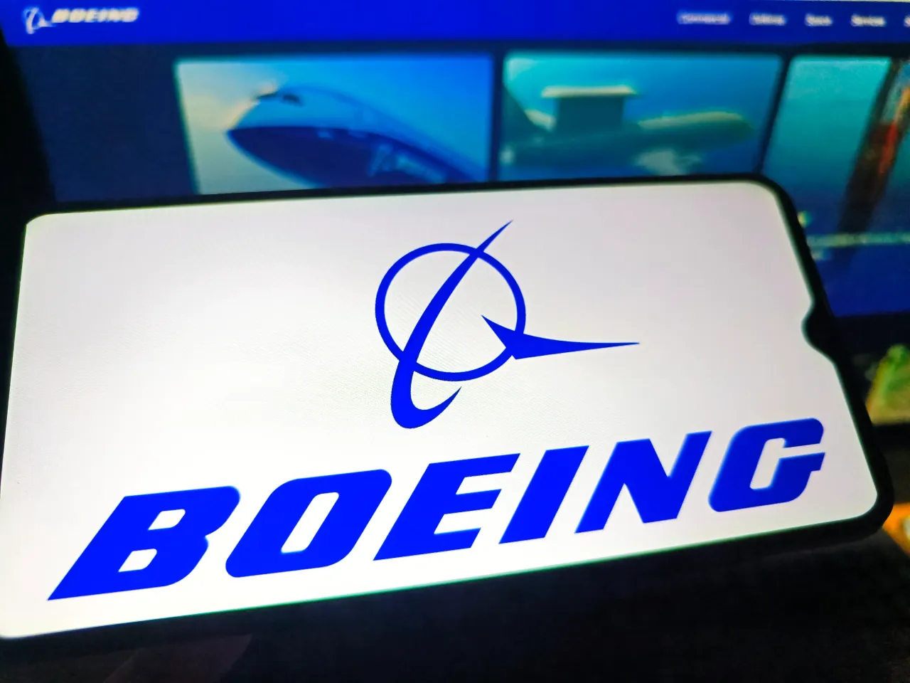 A netizen is checking the BOEING logo on his mobile phone and BOEING webpage on his computer in Suqian City, Jiangsu Province, China.