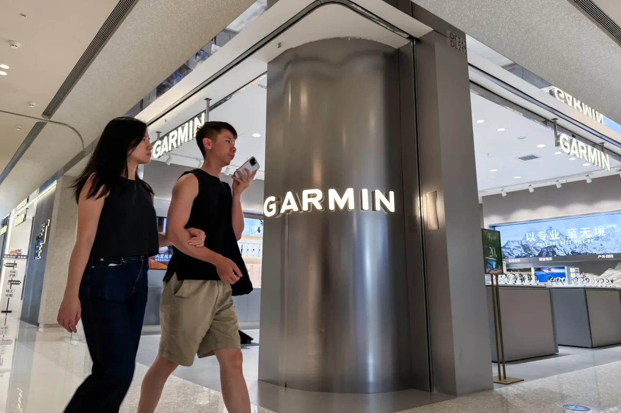 Shoppers walk past a Garmin store in a shopping mall. (Photo by Cheng Xin/Getty Images)