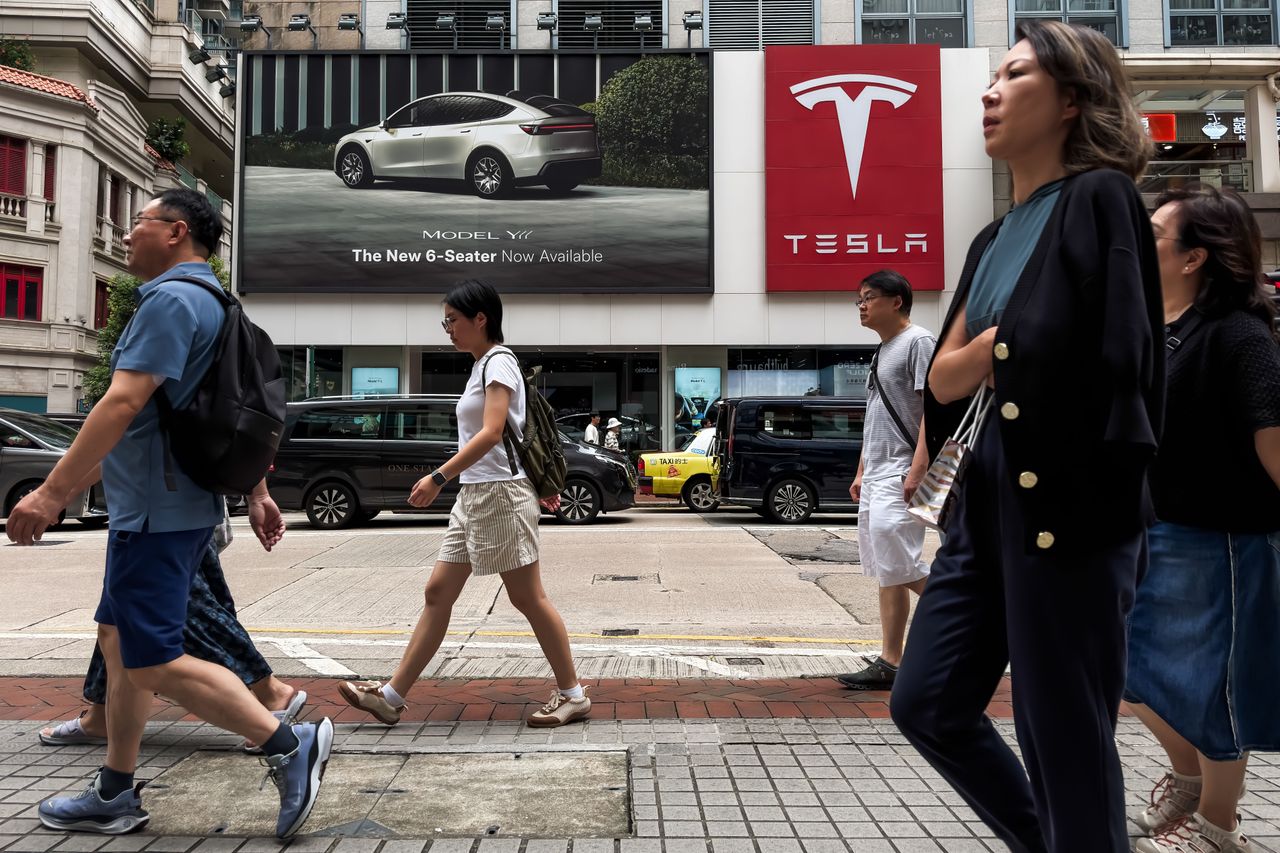Pedestrians walk past a Tesla showroom displaying a billboard advertising the six-seat Model Y on July 10, 2026, in Hong Kong, China. (Photo by Cheng Xin/Getty Images)
