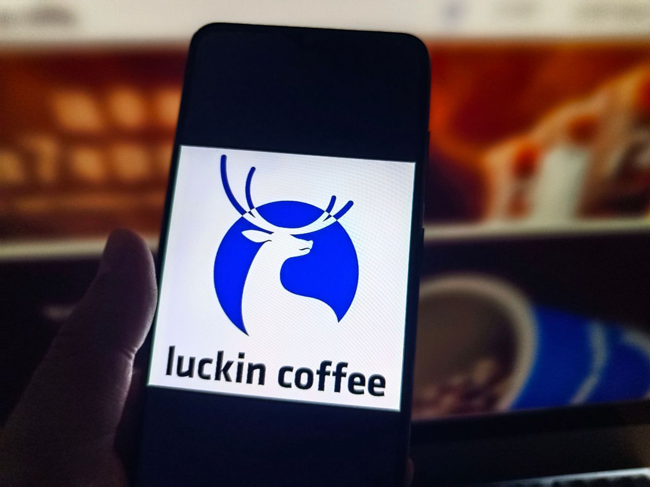 A netizen is using his mobilephone to view Luckin Coffee logo.