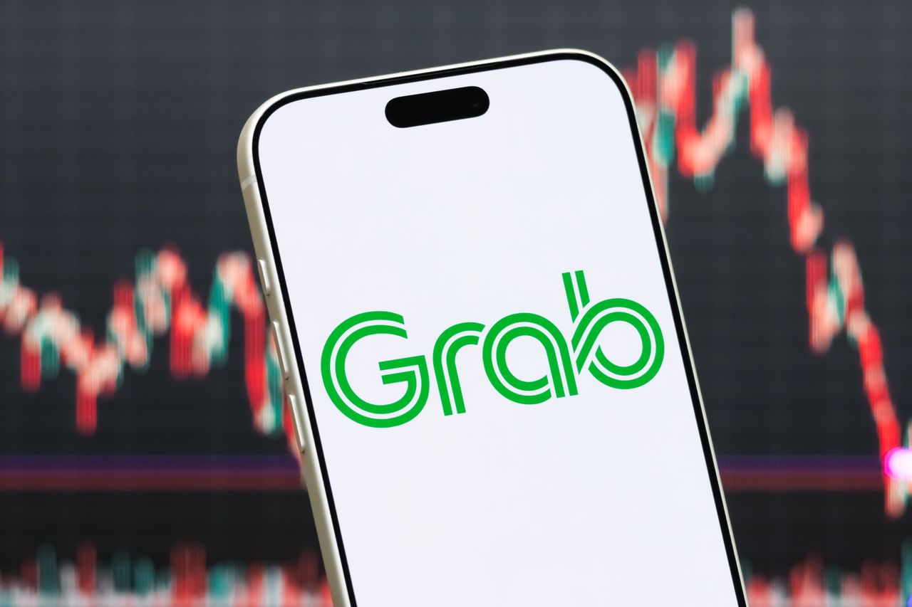 In this photo illustration, a smartphone displays the logo of Grab Holdings Inc.