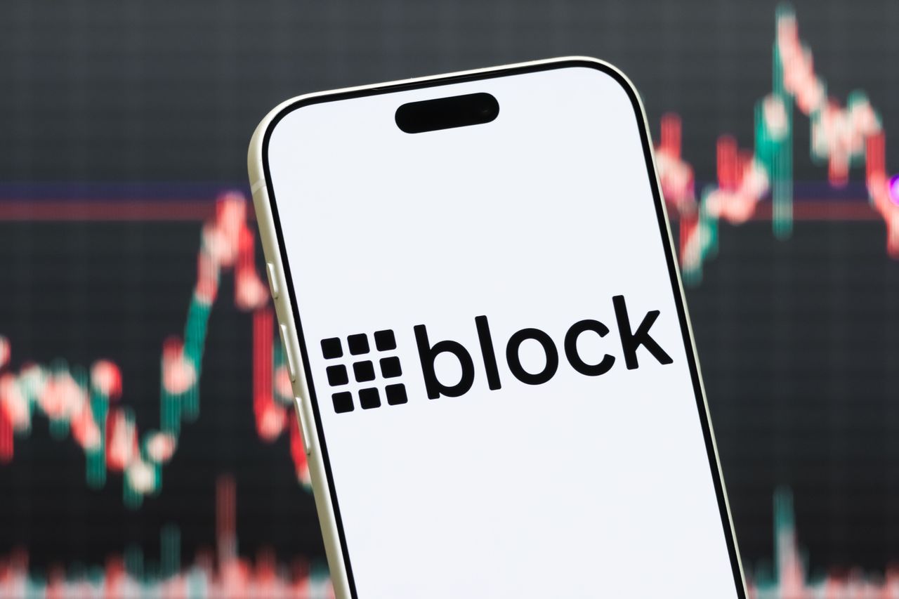 In this photo illustration, a smartphone displays the logo of Block, Inc. (NYSE: XYZ), a financial technology company providing digital payments, banking services and cryptocurrency-related products, in front of a screen showing the company's latest stock market chart on July 27, 2026 in Shenzhen, Guangdong Province, China. (Photo illustration by Cheng Xin/Getty Images)