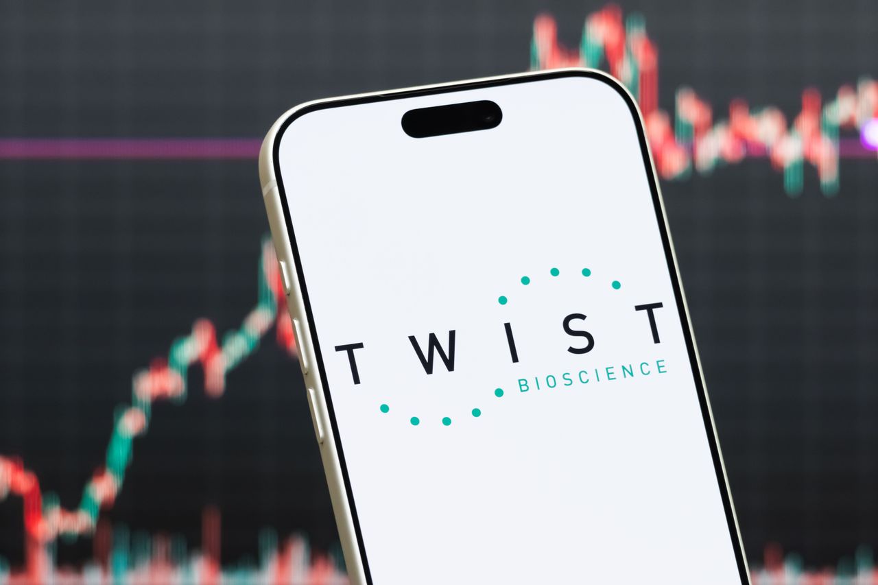 In this photo illustration, a smartphone displays the logo of Twist Bioscience Corporation (NASDAQ: TWST), a synthetic biology company developing DNA synthesis technology and genomic solutions, in front of a screen showing the company's latest stock market chart on July 27, 2026 in Shenzhen, Guangdong Province, China. (Photo illustration by Cheng Xin/Getty Images)