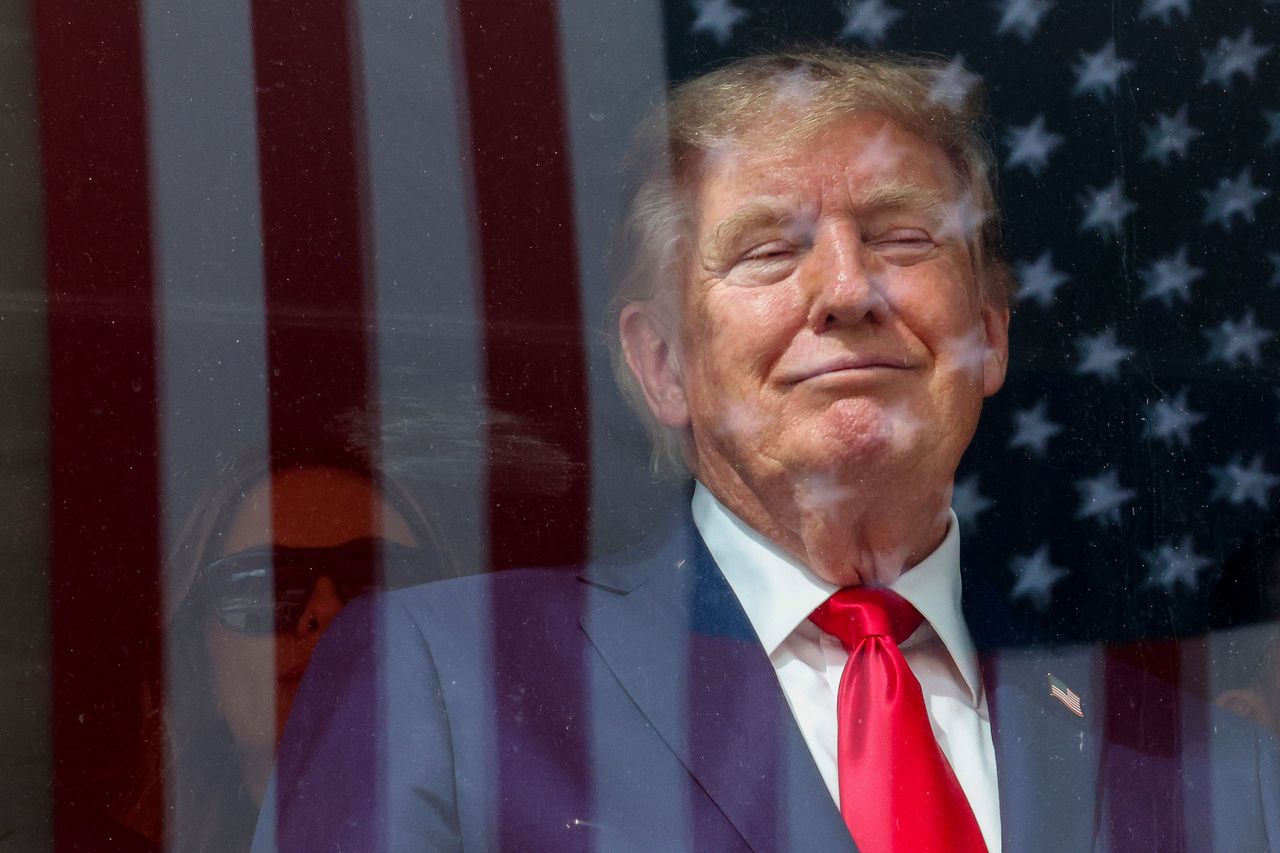 An American flag is reflected off bulletproof glass as U.S. President Donald Trump watches the end of the NTT INDYCAR Series on August 23, 2026 in Washington, DC. (Photo by Mike Kropf/Getty Images)