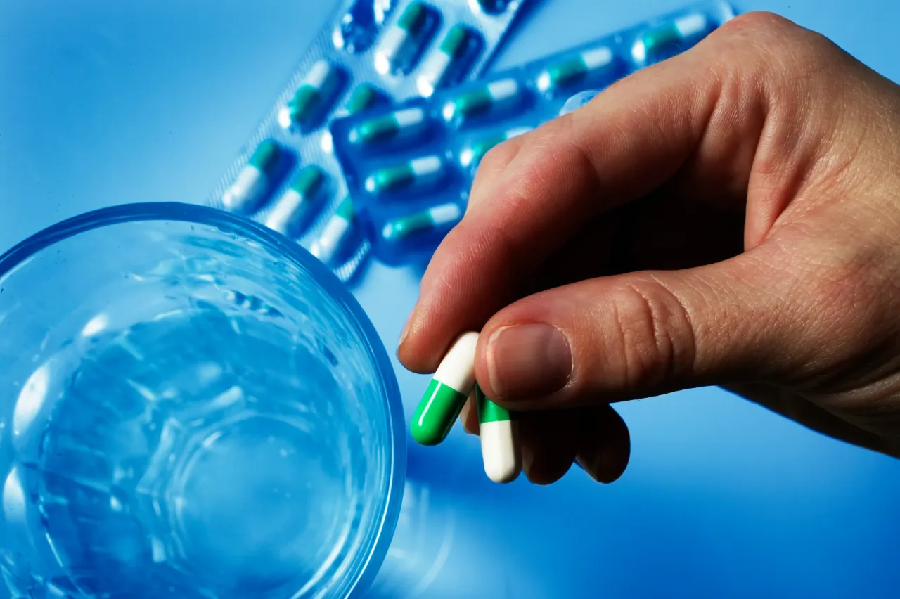 Someone holding a pharmaceutical capsule.