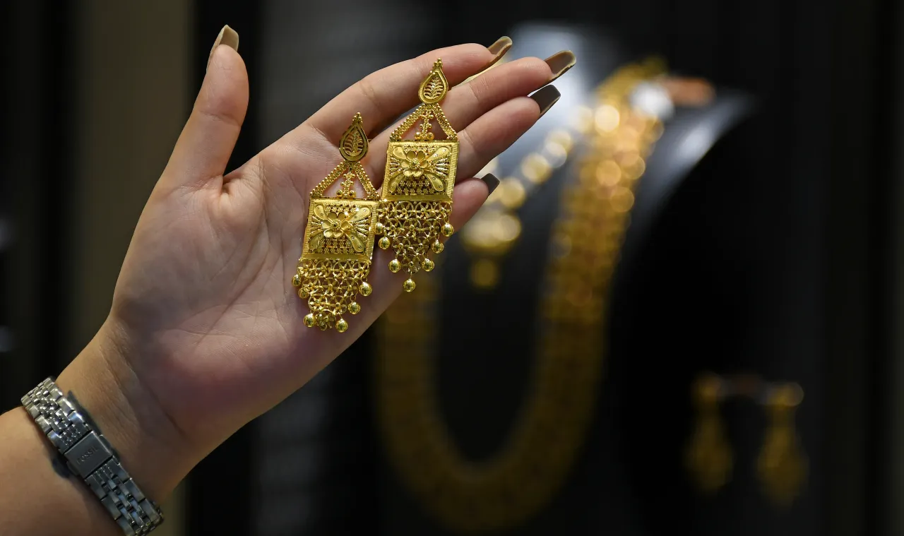A woman checks gold earrings at Kalyan jewellers store in Mumbai.
