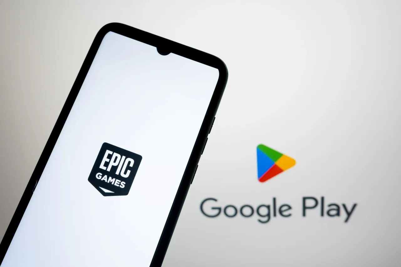 The Epic Games Store logo appears on a smartphone screen, and Google Play Store is displayed as the background, in a photo illustration in Athens, Greece, on August 5, 2025.