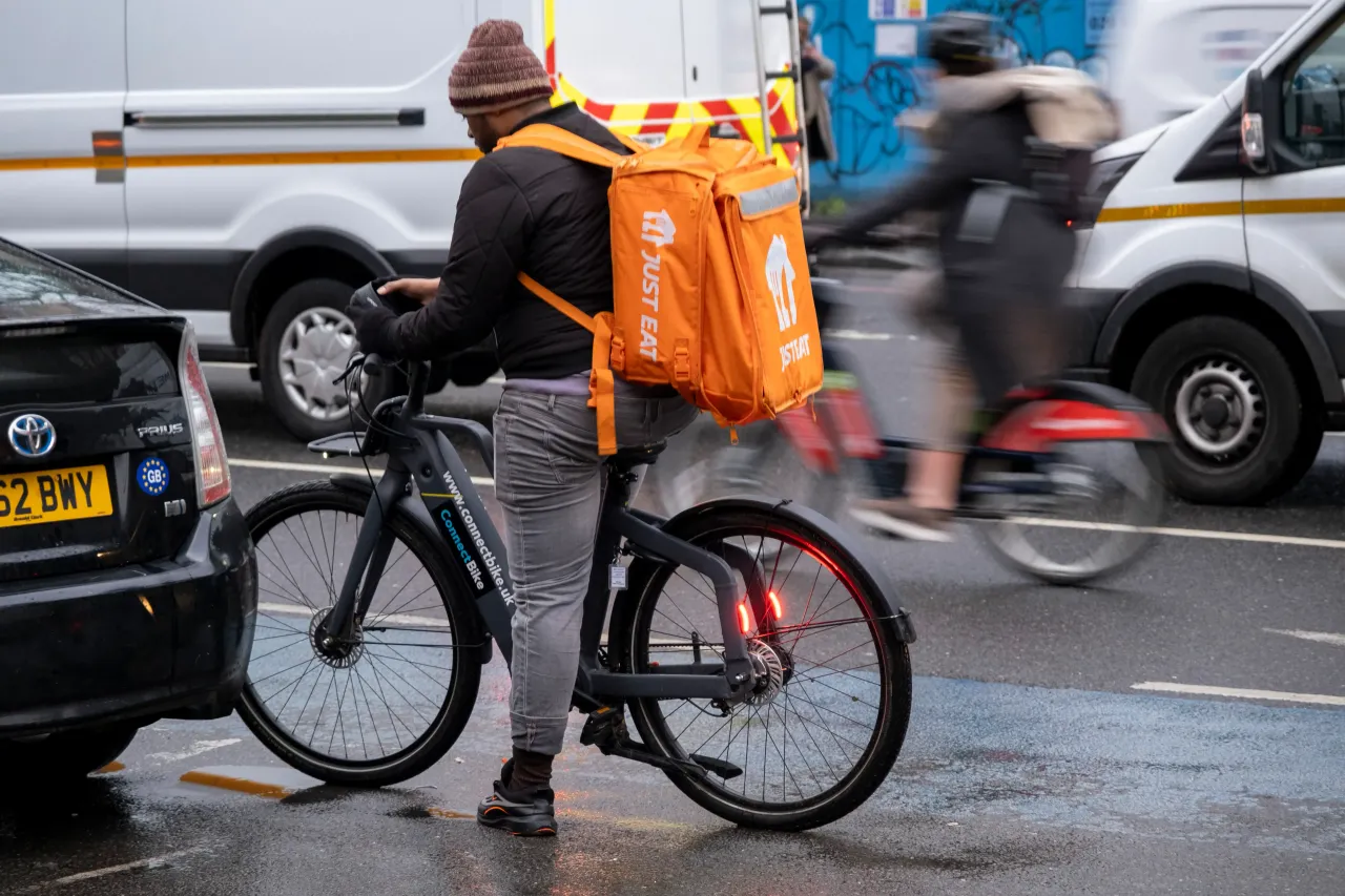 Just Eat takeaway delivery cycle courier in traffic on 31st January 2025 in London, United Kingdom. Just Eat Limited is a British online food order and delivery service founded in 2001. 