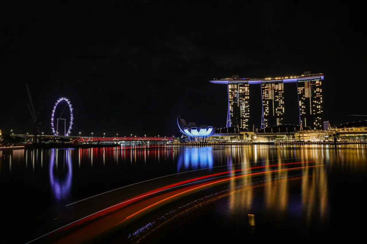 A view of the Singapore Flyer, the ArtScience Museum and Marina Bay Sands are illuminated at night, casting vibrant reflections on the water at Marina Bay on April 13, 2025 in Singapore.