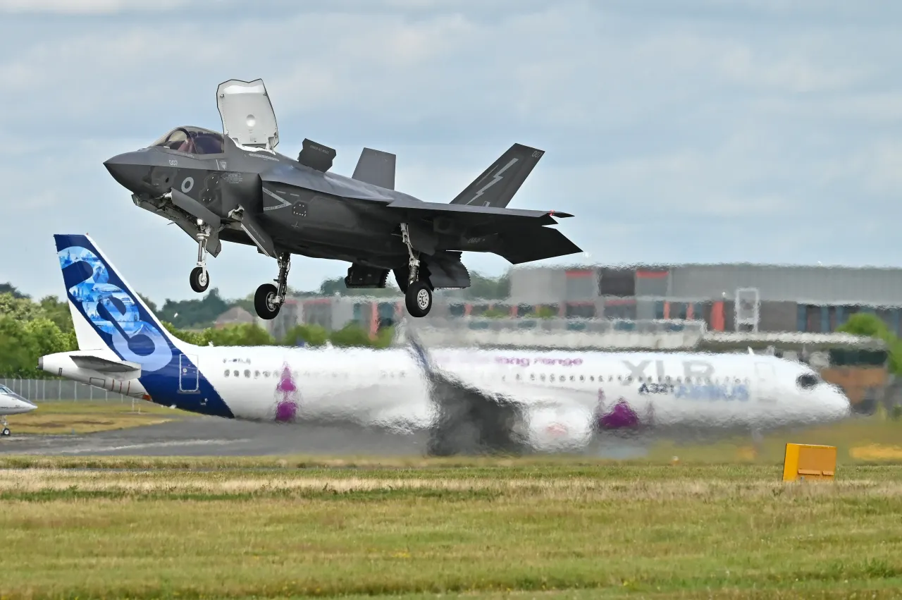 An RAF Lockheed Martin F-35 lightning II performs with a Airbus A321 253 XLR Neo in the background during the Farnborough International Airshow 2024, England. 