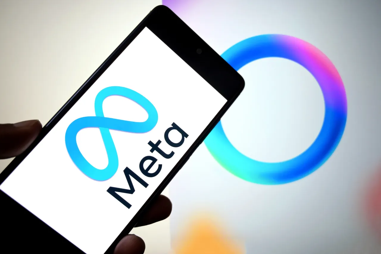 In this photo illustration, a Meta logo is seen displayed on a smartphone with a Meta AI logo in the background. 
