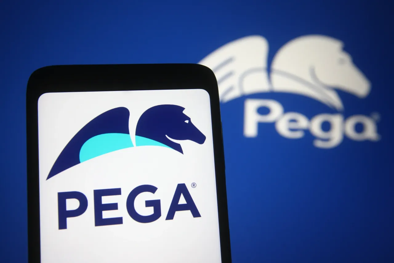 In this photo illustration, the Pegasystems logo of a US software company is seen on a smartphone and a pc screen. 