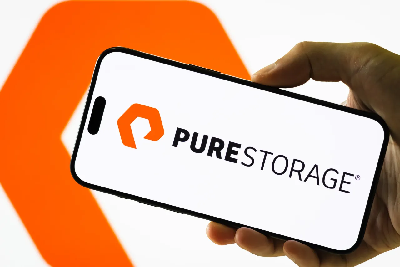 In this photo illustration, a hand holds a smartphone displaying the logo of Pure Storage Inc. (NYSE: PSTG). 