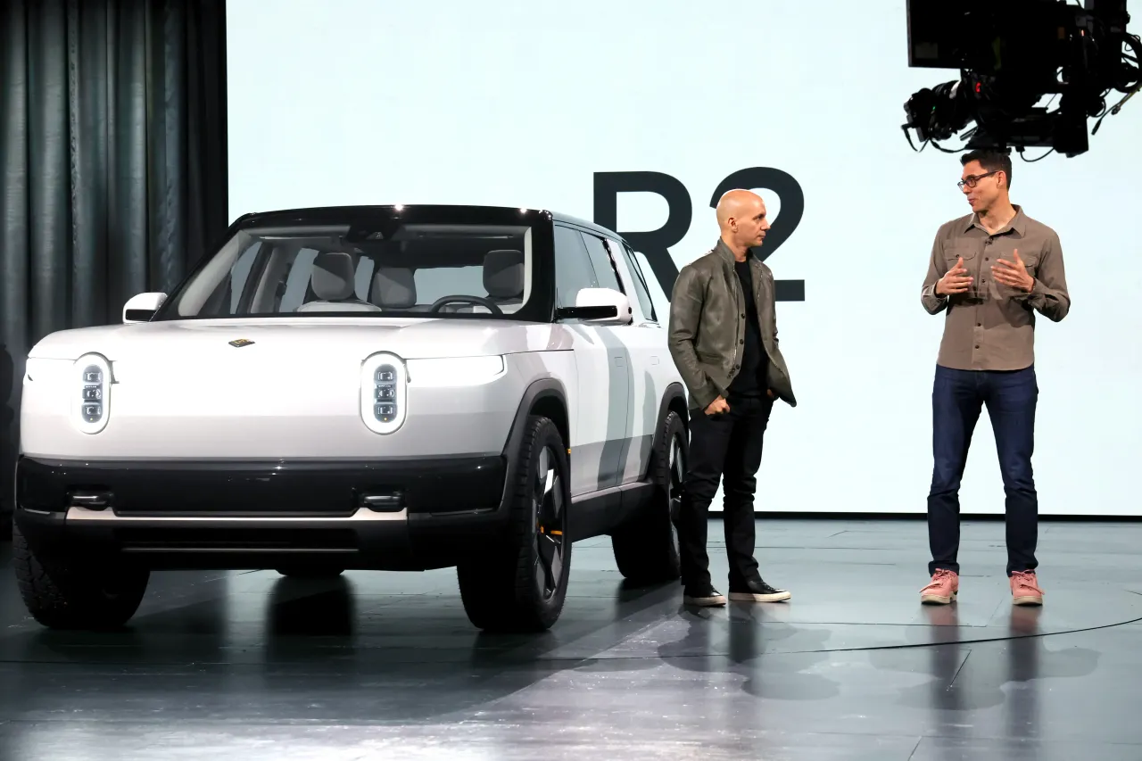 Chief Design Officer of Rivian Jeff Hammoud and Founder and CEO of Rivian RJ Scaringe speak onstage during the Rivian Reveals All-Electric R2 Midsize SUV event
