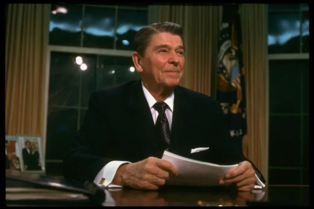 President Ronald Reagan sitting at desk in the Oval Office of the White House after adressing the nation, re Iran-Contra affair. 