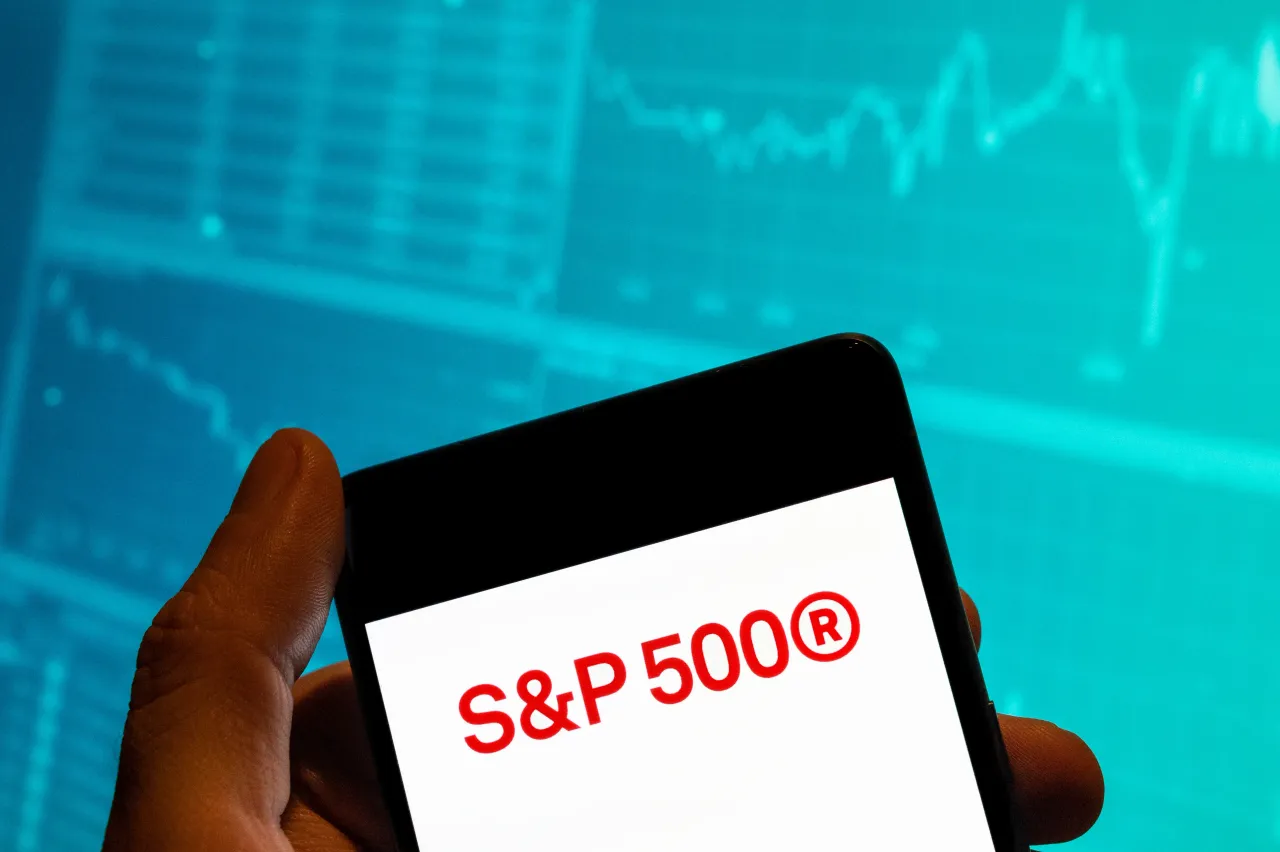 In this photo illustration, the US stock market index tracking the stock performance of 500 large companies listed S&P 500 logo is seen displayed on a smartphone. 