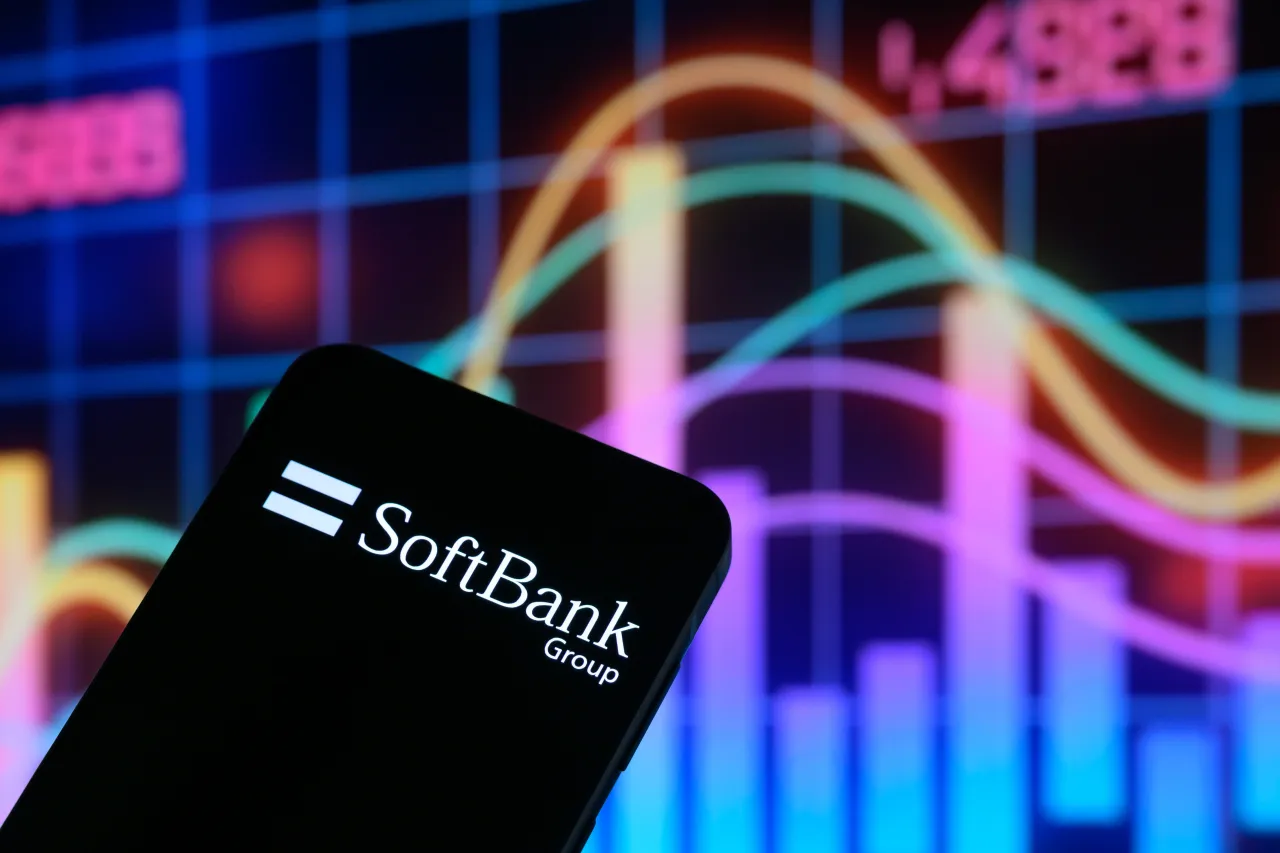 The SoftBank Group logo is displayed on a mobile phone with a stock graph in the background, in this photo illustration in Brussels, Belgium, on August 20, 2025. 