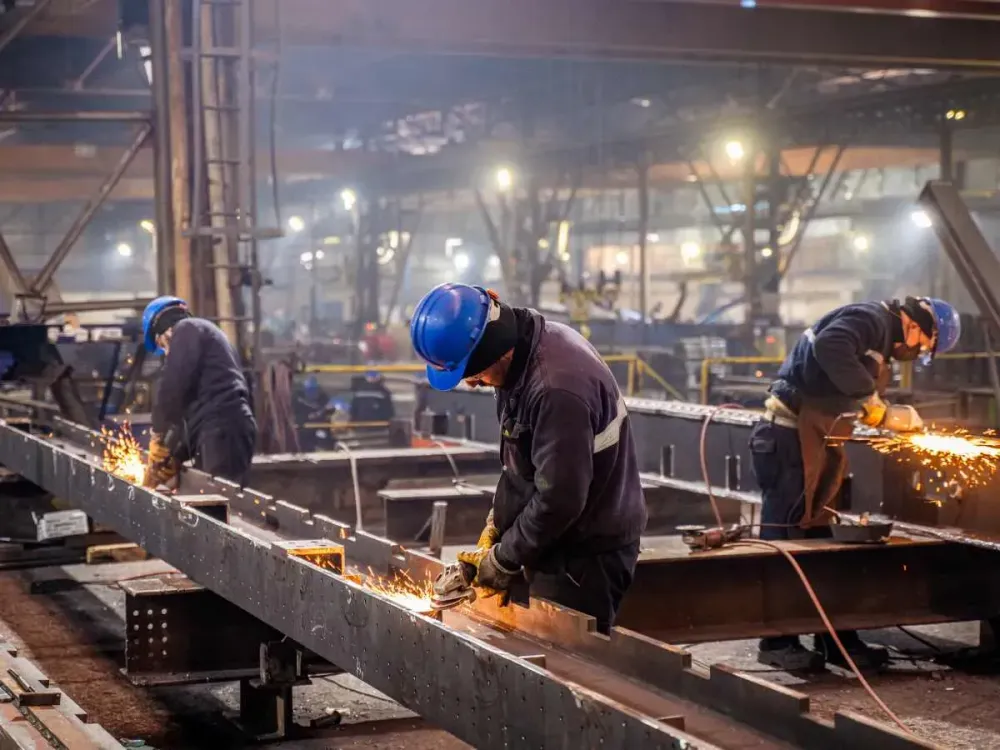 Metal workers using a grinder.