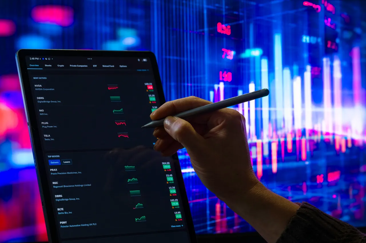 A person views trading stocks on a tablet on the last day of the 2025 trading market in Brussels, Belgium, on December 30, 2025.