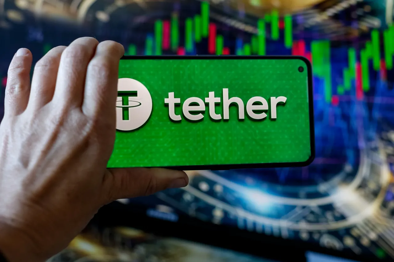 In this photo illustration, the Tether (USDT) logo seen displayed on a smartphone with stock market graphs in the background. (Photo Illustration by Dominika Zarzycka/SOPA Images/LightRocket via Getty Images)