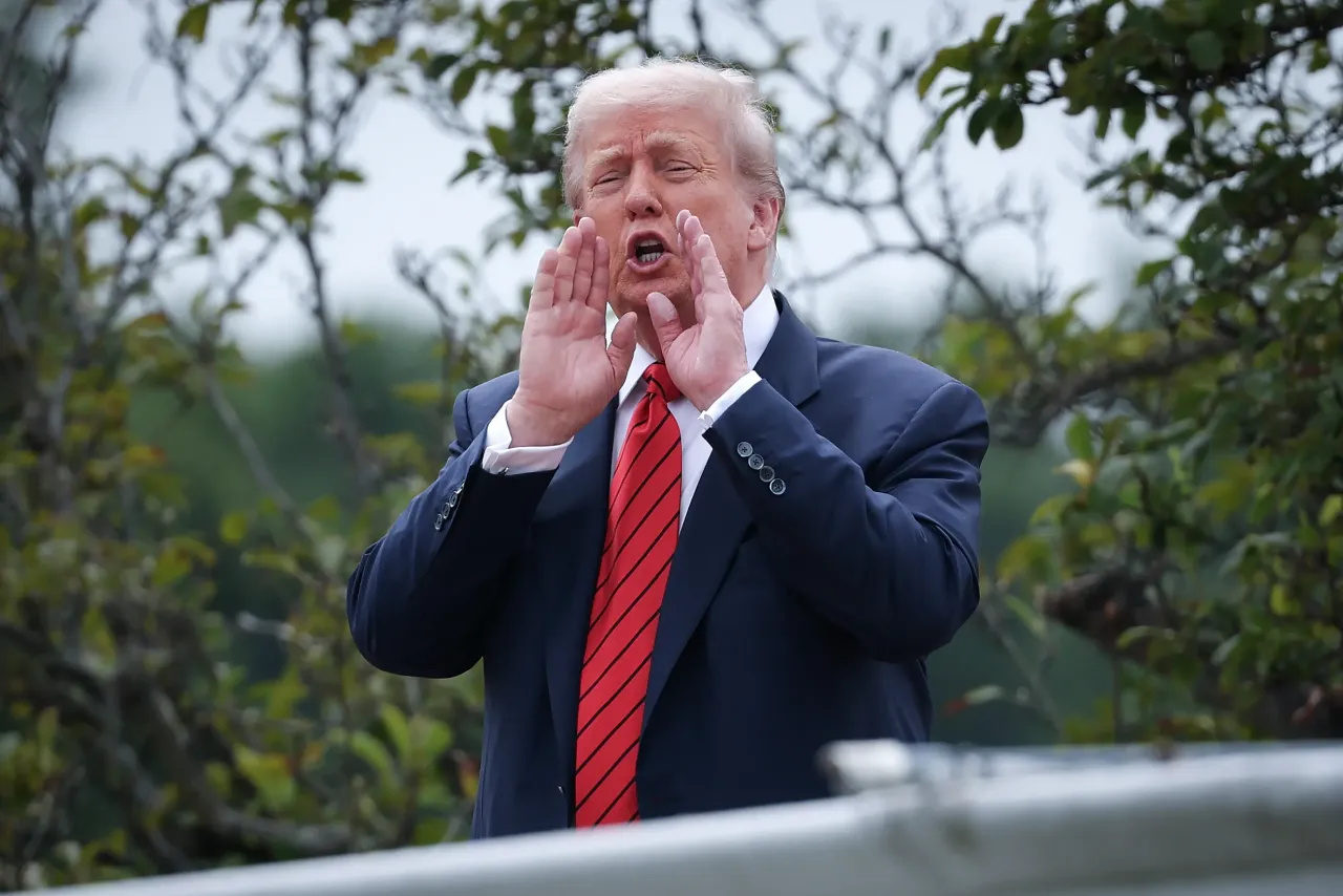U.S. President Donald Trump shouts answers to questions from reporters as he tours the roof of the West Wing of the White House on August 05, 2025, in Washington, DC. 