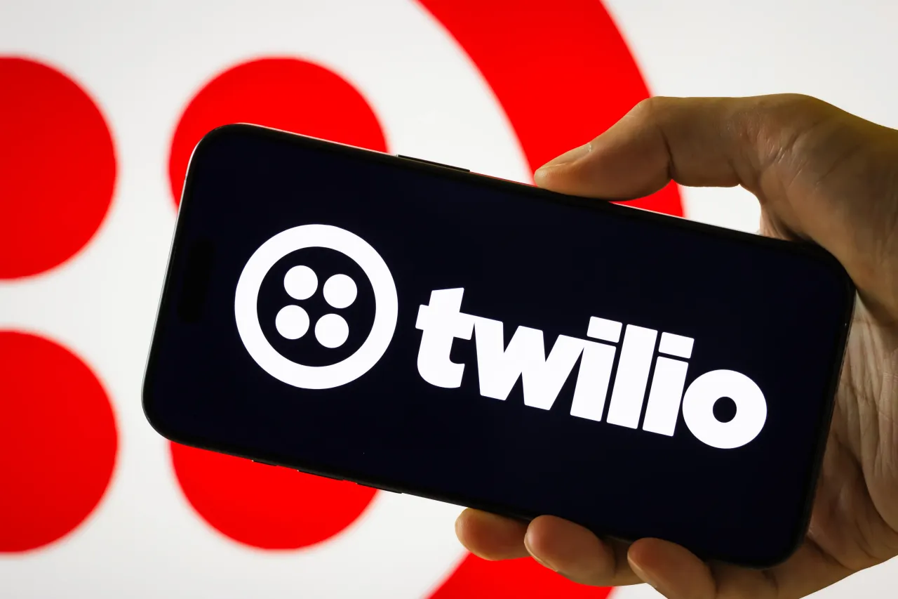 In this photo illustration, a person holds a smartphone displaying the logo of Twilio Inc. (NYSE: TWLO), a cloud communications platform as a service (CPaaS) company, on August 7, 2025, in Chongqing, China. 
