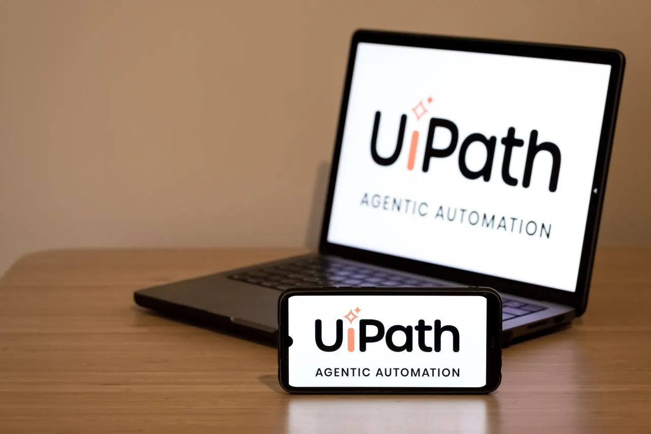 The UiPath logo appears on a smartphone screen and on a laptop computer screen in this photo illustration in Athens, Greece, on October 3, 2025. 