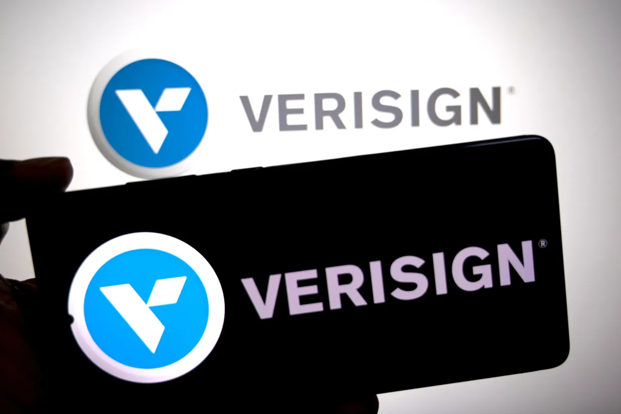 In this photo illustration, the VERISIGN logo is seen displayed on a smartphone and in the background. 