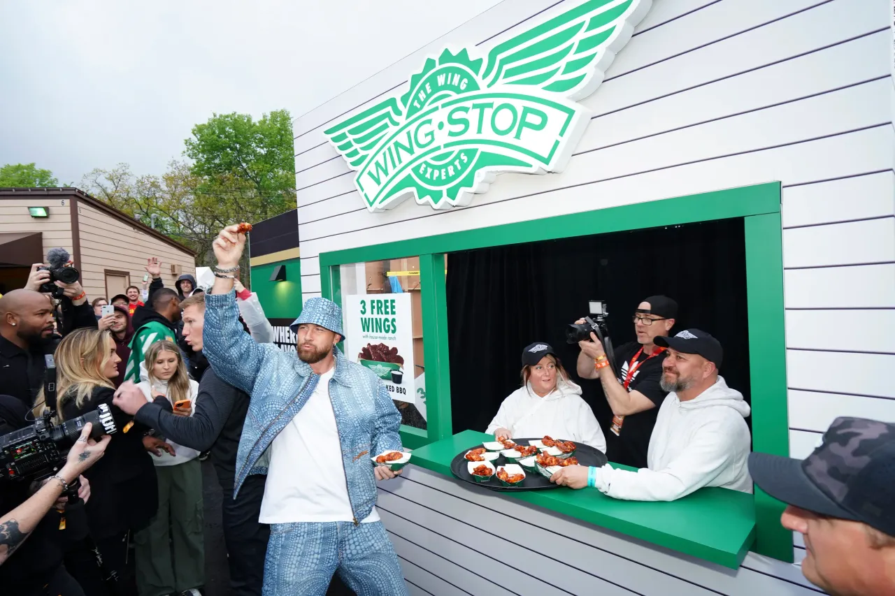 Travis Kelce #52 of the Kansas City Chiefs samples wings at a Wingstop food stand during Kelce Jam at Azura Amphitheater on April 28, 2023 in Bonner Springs, Kansas.