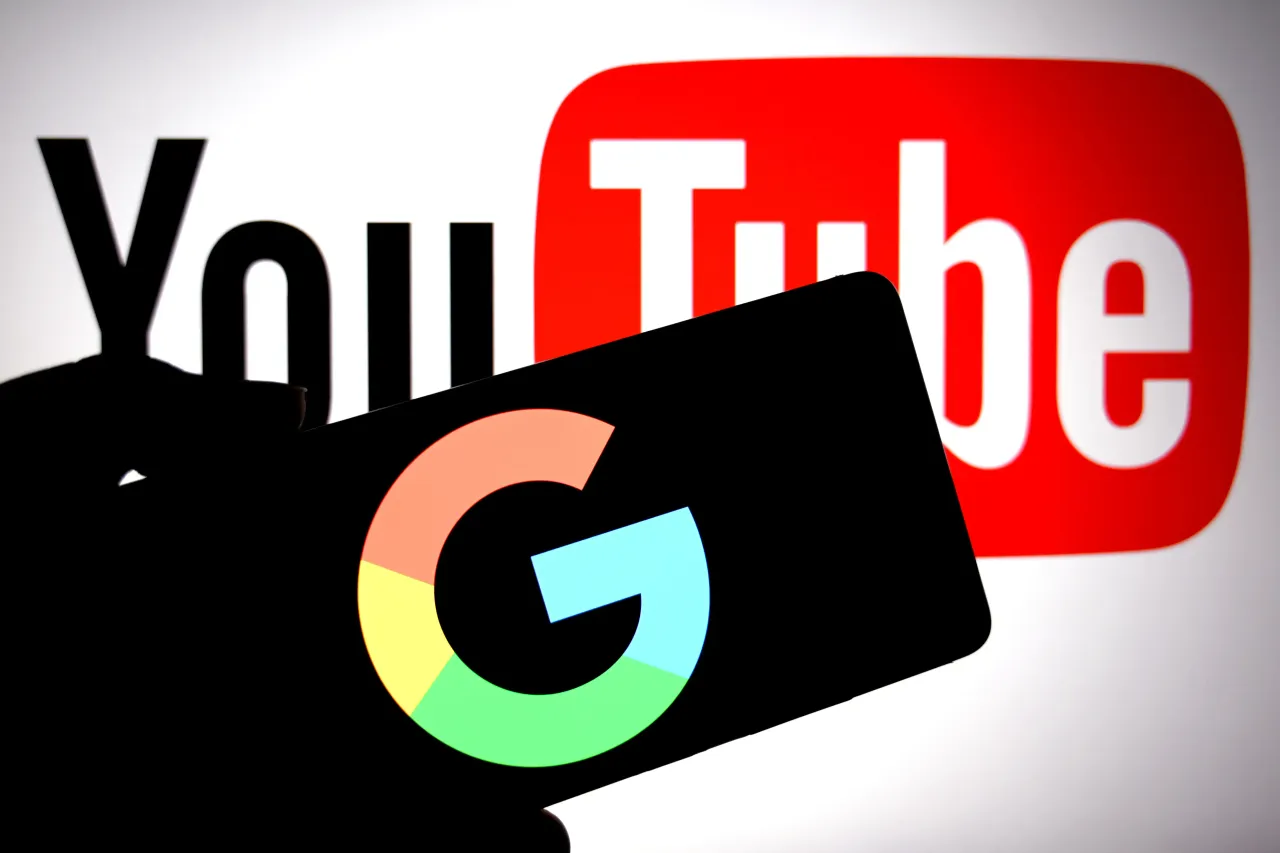 In this photo illustration, a Google logo is seen displayed on a smartphone with a YouTube logo in the background. 