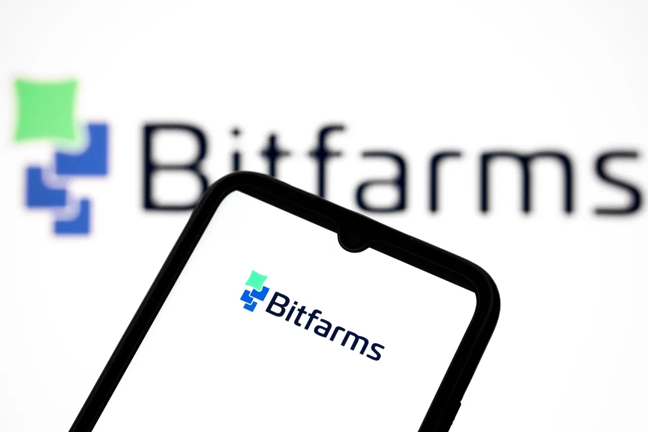 The Bitfarms logo appears on a smartphone screen and as the background on a laptop computer screen in this photo illustration in Athens, Greece, on September 25, 2025. (Photo by Nikolas Kokovlis/NurPhoto via Getty Images)