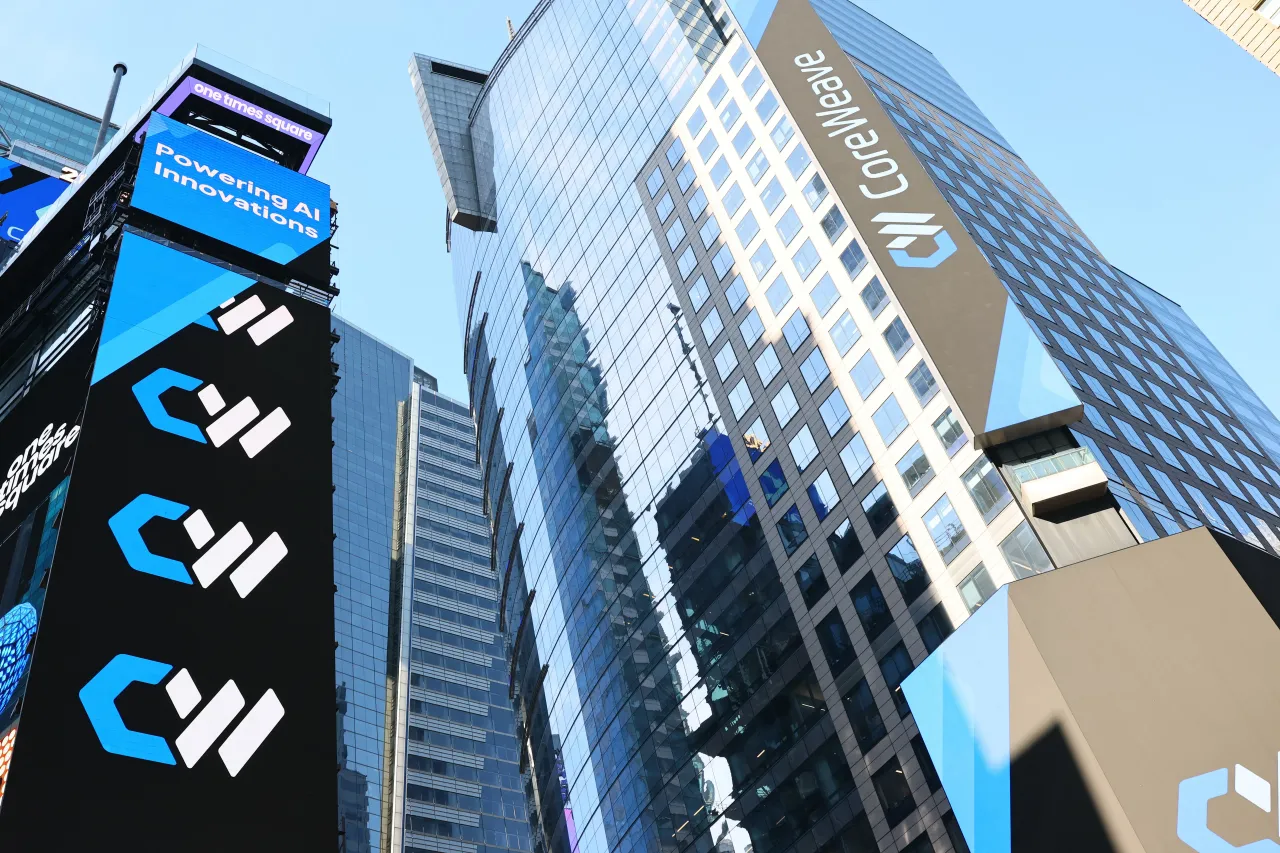  The CoreWeave company name and logo are displayed on digital billboards in Times Square during the company's Initial Public Offering (IPO) at the Nasdaq headquarters on March 28, 2025 in New York City. (Photo by Michael M. Santiago/Getty Images)