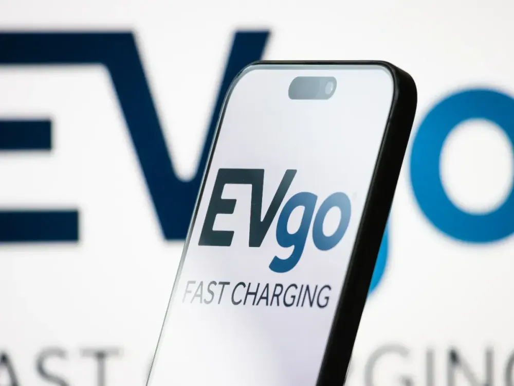 In this photo illustration, the logo of EVgo Inc. is displayed on a smartphone screen, with the company's branding visible in the background. (Photo illustration by Cheng Xin/Getty Images)