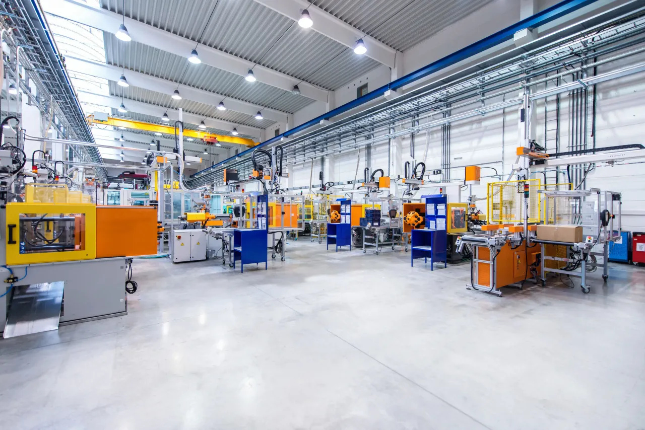 Image of huge new modern factory with robots and machines producing industrial plastic pieces and equipment