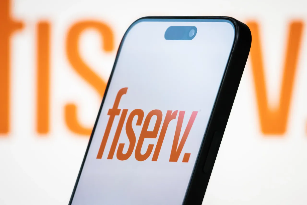 In this photo illustration, the Fiserv logo is displayed on a smartphone screen, with the company's branding visible in the background, on April 20, 2025, in Chongqing, China. (Photo by Cheng Xin/Getty Images)