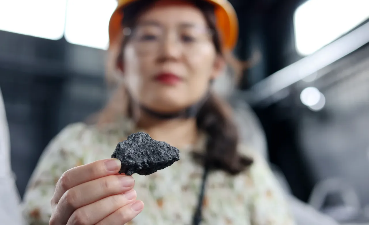 A staff member shows the production of calcined coke at the production workshop of Zhonghai Graphite in Binzhou, China