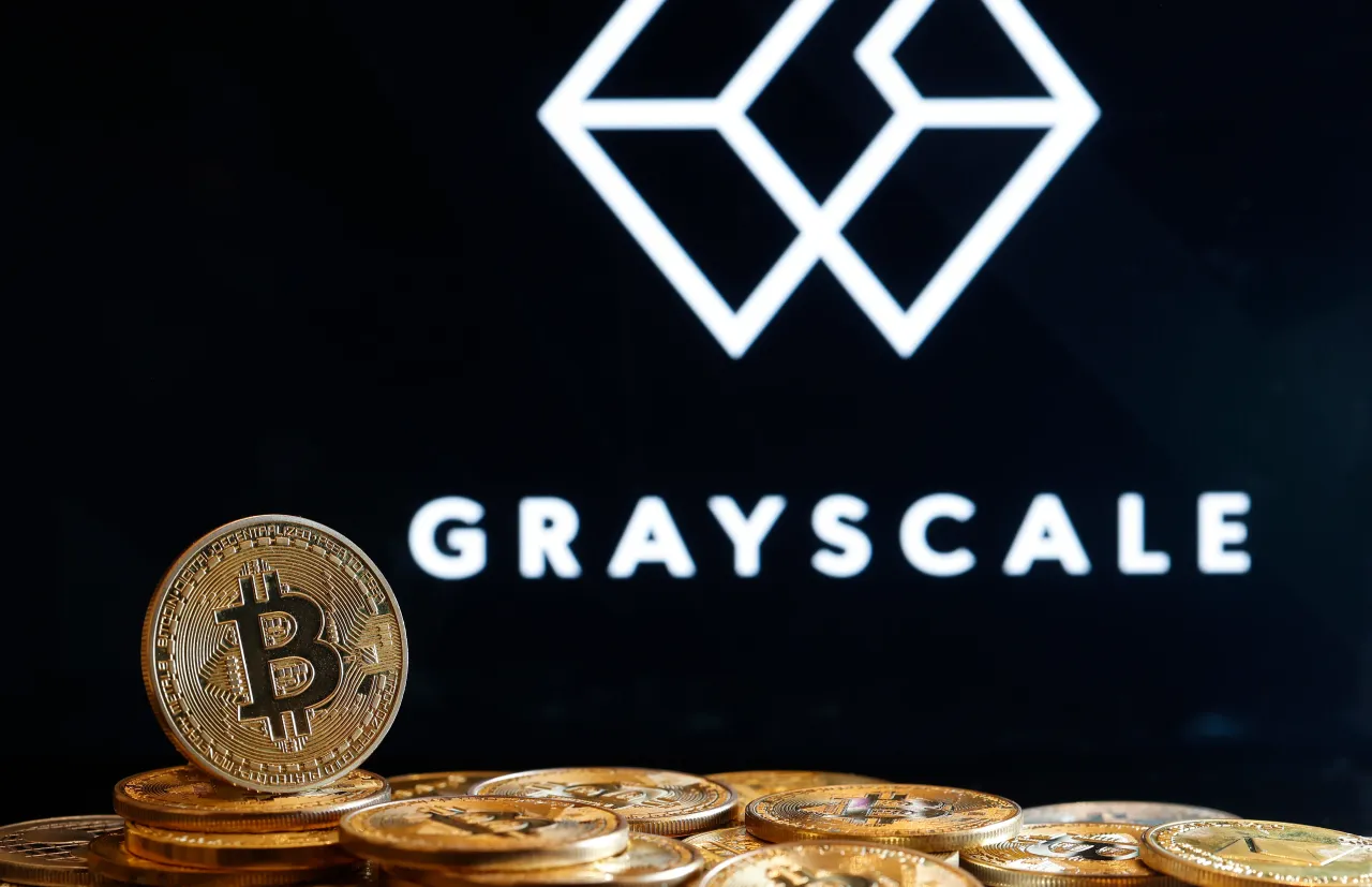 In this photo illustration, a visual representation of the digital cryptocurrency Bitcoin is displayed in front of the logo of Grayscale Investments on January 10, 2024 in Paris, France. (Photo illustration by Chesnot/Getty Images)