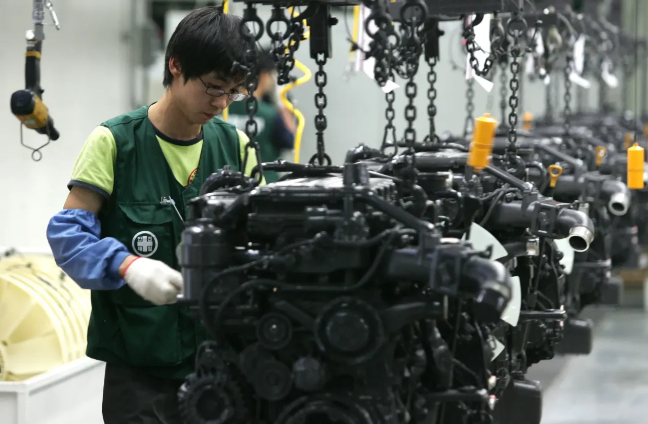 An employee works on an engine assembly line for a Hyundai trucks and bus at the JeonJu plant on October 17, 2007 in JeonJu, South Korea. (Photo by Chung Sung-Jun/Getty Images)