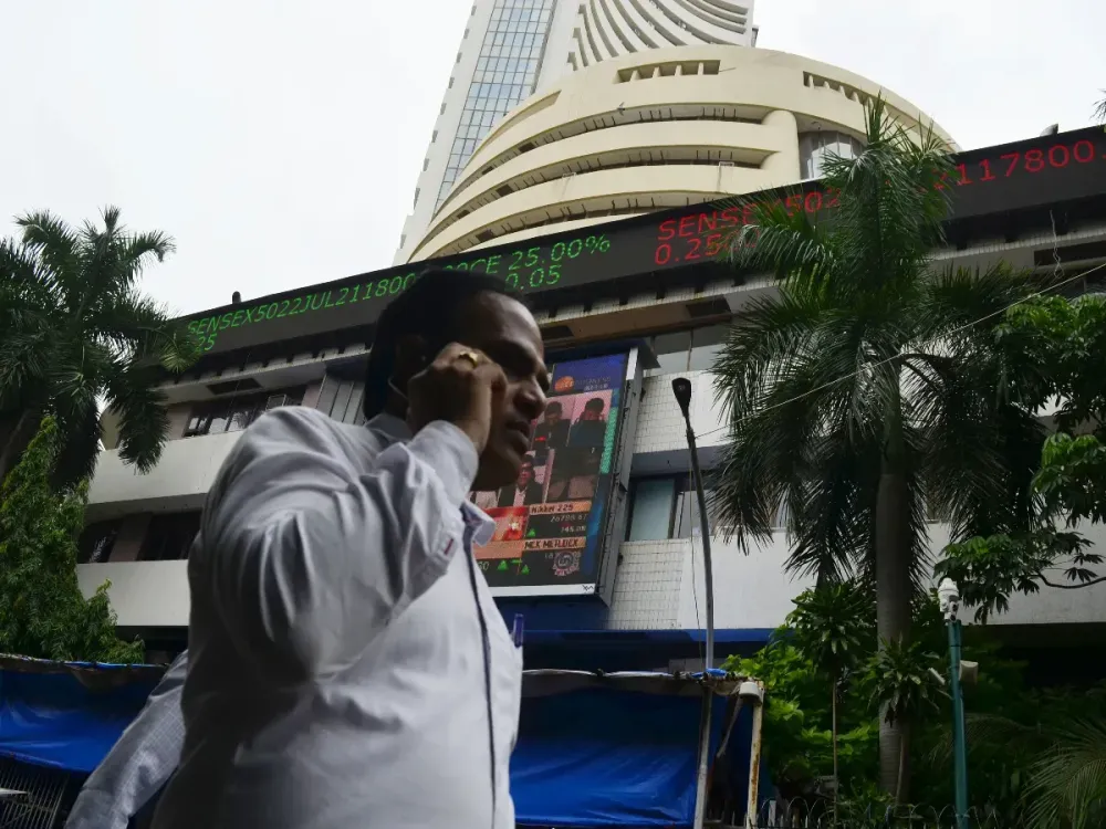 A man on phone walks past Bombay Stock Exchange office in Mumbai, India, 18 July, 2022. (Photo by Indranil Aditya/NurPhoto via Getty Images)